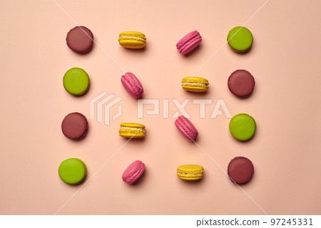 Colored macaron or macaroon, sweet meringue-based confection on pink background. Close-up, copy space. 97245331