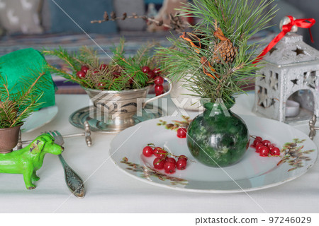 New Year's table setting with linen tablecloth, candles and spruce branches New Year's table setting with linen tablecloth, candles and spruce branches 97246029