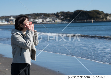 Woman shouting at the winter sea 97246908