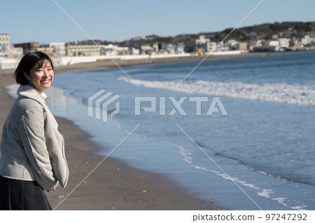 一個微笑的女人，背景是冬天的大海 97247292