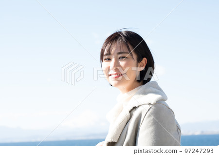 一個微笑的女人，背景是冬天的大海 97247293