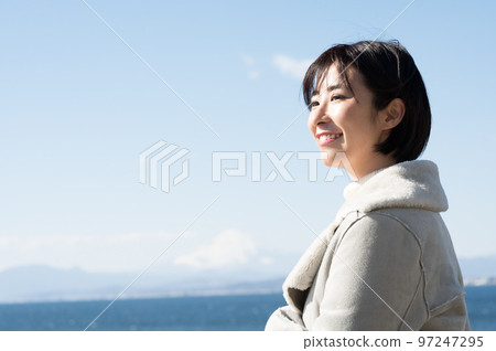 A smiling woman with the winter sea in the background 97247295