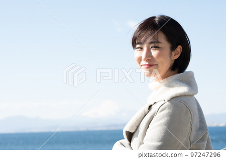 A smiling woman with the winter sea in the background 97247296