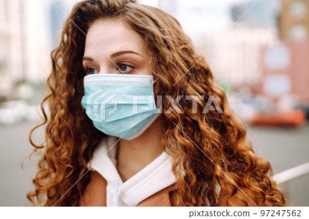 Woman in protective medical mask on her face on the street. Woman, wear face mask. Corona virus. 97247562