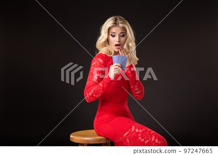 Young woman in casino with cards over black background. Poker 97247665
