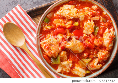 Bacalao al ajoarriero Cod with peppers and tomato sauce closeup on the bowl. Horizontal top view Bacalao al ajoarriero Cod with peppers and tomato sauce closeup on the bowl. Horizontal top view 97247742