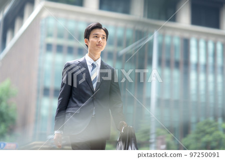 Businessman walking in the office town 97250091