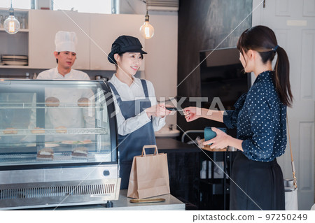 在糖果店用信用卡付款的女人 97250249