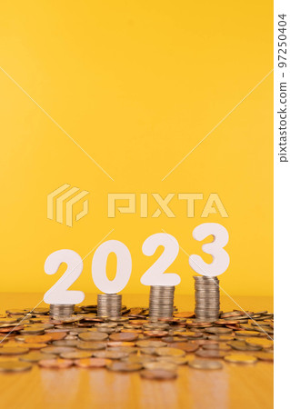 2023 New year saving money and financial planning concept. Stack of coins with number 2023 on wood table over gold background. Creative idea for business growth, investment, profit and banking. 97250404
