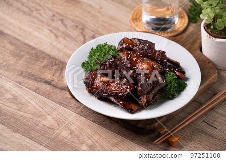 Barbecue pork spare ribs in a plate on wooden table background. 97251100