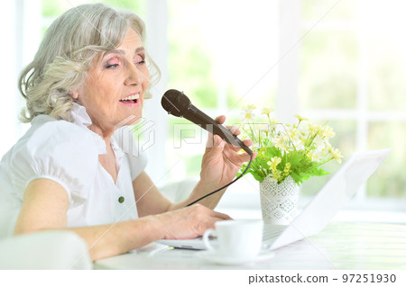 Portrait of beautiful old woman singing with microphone 97251930