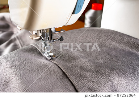 Modern sewing machine and gray fabric. Sewing process, handmade, hobby, DIY, business, repair 97252064