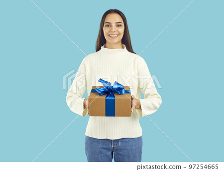 Studio portrait of happy beautiful young woman holding gift box with Christmas present Studio portrait of happy beautiful young woman holding gift box with Christmas present 97254665