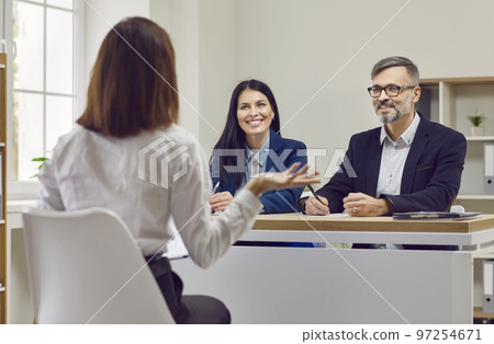 HR managers listening to a candidate while sitting at a desk during a job interview HR managers listening to a candidate while sitting at a desk during a job interview 97254671