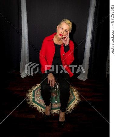 Attractive blonde woman wearing a red coat Attractive blonde woman wearing a red coat 97255502