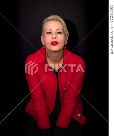 Attractive blonde woman wearing a red coat Attractive blonde woman wearing a red coat 97255503