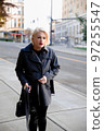 Fashionable blonde woman walking exploring the city. 97255547