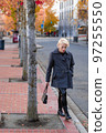 Fashionable blonde woman walking exploring the city. 97255550