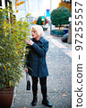 Fashionable blonde woman walking exploring the city. 97255557