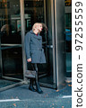 Fashionable blonde woman walking exploring the city. 97255559