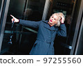 Fashionable blonde woman walking exploring the city. 97255560