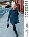 Fashionable blonde woman walking exploring the city. 97255565
