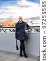 Fashionable blonde woman walking exploring the city. 97255585