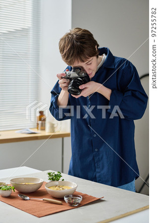 Professional photographer taking photo of food with digital camera during her work in studio Professional photographer taking photo of food with digital camera during her work in studio 97255782