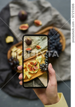 High angle view of young woman photographing exotic fruits on tray using her smartphone with perfect camera High angle view of young woman photographing exotic fruits on tray using her smartphone with perfect camera 97255806