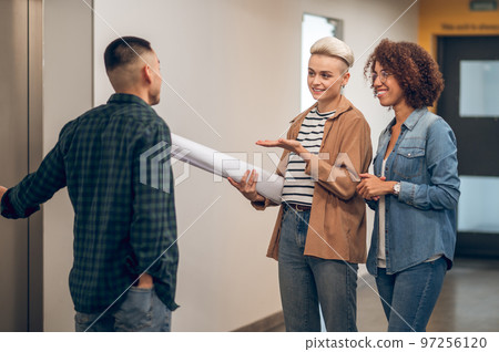 Three company employees waiting together for the elevator Three company employees waiting together for the elevator 97256120