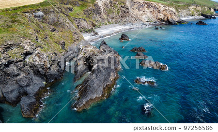 Steep cliffs on the coast of Ireland. Turquoise waters of the Atlantic Ocean. Natural beauties of Ireland, West Cork. The rocky coast of the Celtic Sea. Aerial photo. Steep cliffs on the coast of Ireland. Turquoise waters of the Atlantic Ocean. Natural beauties of Ireland, West Cork. The rocky coast of the Celtic Sea. Aerial photo. 97256586