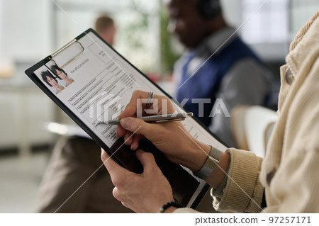 Portrait of mature woman working in services office and using laptop while consulting male client 97257171