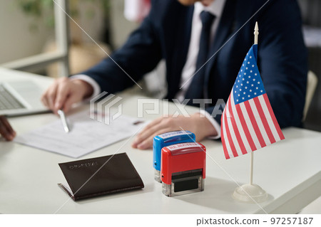 Close up of approved and rejected stamps on table in US immigration office with flag, copy space 97257187