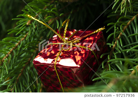 Christmas gift on the background of the Christmas tree close-up Christmas gift on the background of the Christmas tree close-up 97257936