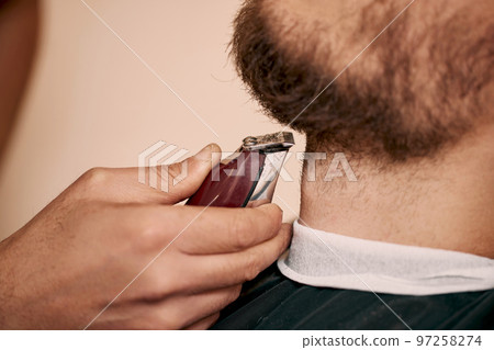 Barber shaving caucasian man in barber shop 97258274