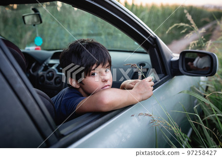 thoughtful girl with short dark har watching from family car windows 97258427