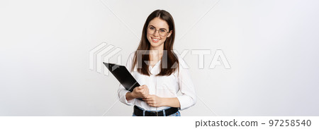 Portrait of corporate woman holding clipboard at work, standing in formal outfit over white background Portrait of corporate woman holding clipboard at work, standing in formal outfit over white background 97258540