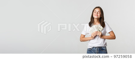 Happy and satisfied smiling woman close eyes and enjoying having money 97259058