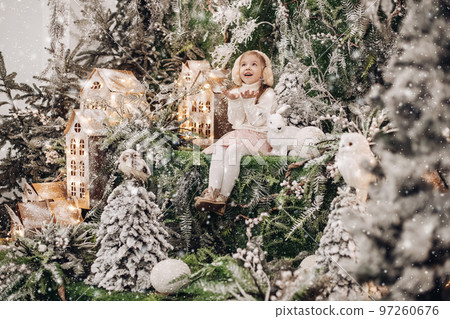 Cute girl in earmuffs catching snow with hands. 97260676