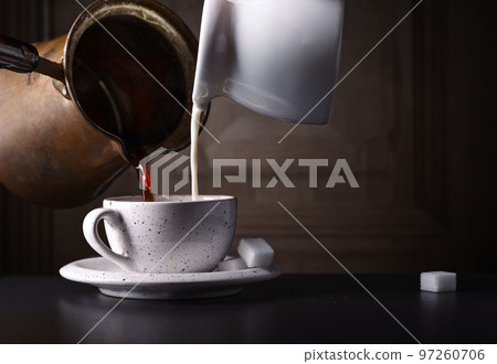 Cup of coffee with milk and sugar on black table Cup of coffee with milk and sugar on black table 97260706