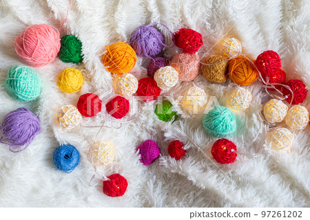 A lot of colorful knitting yarn in the form of balls lie on fluffy blanket. A lot of colorful knitting yarn in the form of balls lie on fluffy blanket. 97261202