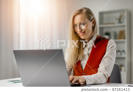 Woman working on laptop Woman working on laptop 97261413