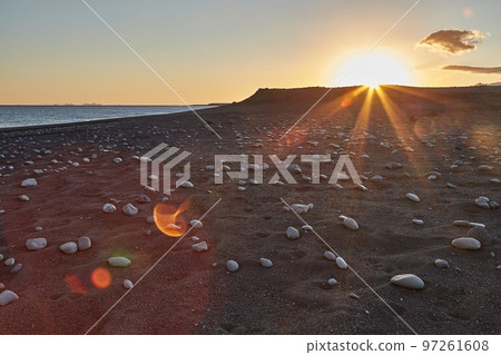 Iceland landscape black sand beach with stones and sunset flare Iceland landscape black sand beach with stones and sunset flare 97261608