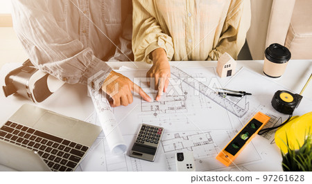 Two engineers pointing at drawings project, Architect team meeting consult and work for architectural construction project working with partner and engineering after editing on blueprint paper plans Two engineers pointing at drawings project, Architect team meeting consult and work for architectural construction project working with partner and engineering after editing on blueprint paper plans 97261628