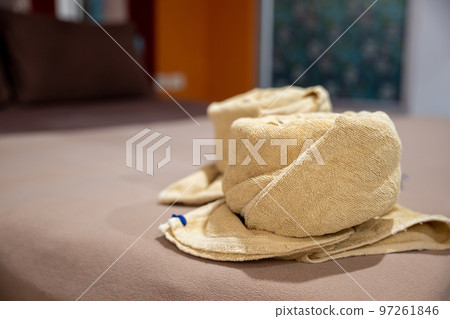 Yellow towel on bed decoration in bedroom interior, Freshly laundered fluffy towels, Towel in hotel room, Beautifully folded toiletries Yellow towel on bed decoration in bedroom interior, Freshly laundered fluffy towels, Towel in hotel room, Beautifully folded toiletries 97261846