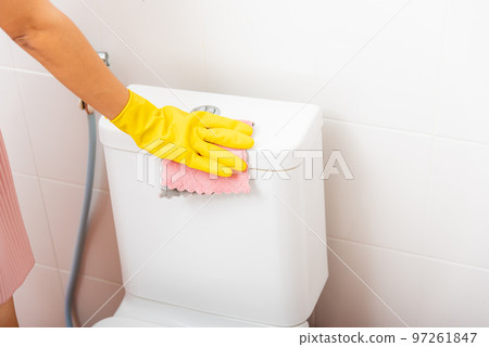 Woman cleaning toilet seat by pink cloth wipe restroom, female wearing yellow rubber gloves she sitting and clean the bathroom, Housekeeper healthcare concept Woman cleaning toilet seat by pink cloth wipe restroom, female wearing yellow rubber gloves she sitting and clean the bathroom, Housekeeper healthcare concept 97261847