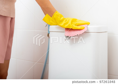 Hands of Asian woman cleaning toilet seat by pink cloth wipe restroom at house, female wearing yellow rubber gloves she sitting and cleanup or washing bathroom, Housekeeper healthcare concept Hands of Asian woman cleaning toilet seat by pink cloth wipe restroom at house, female wearing yellow rubber gloves she sitting and cleanup or washing bathroom, Housekeeper healthcare concept 97261848