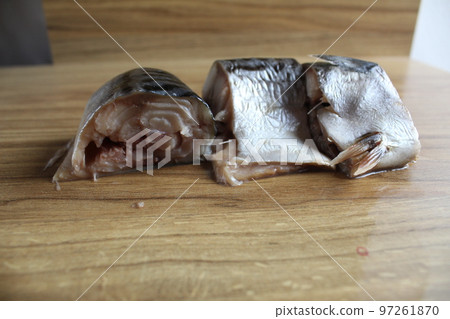 three pieces of mackerel lie sliced on the wooden surface of the table. Homemade fish cooking. Healthy food 97261870