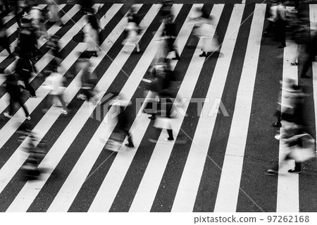 The city of Osaka in December. People crossing the pedestrian crossing pass quickly. Taken in monochrome The city of Osaka in December. People crossing the pedestrian crossing pass quickly. Taken in monochrome 97262168