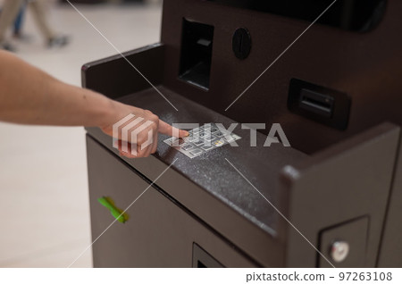 Faceless woman dialing bank card pin at ATM. Faceless woman dialing bank card pin at ATM. 97263108